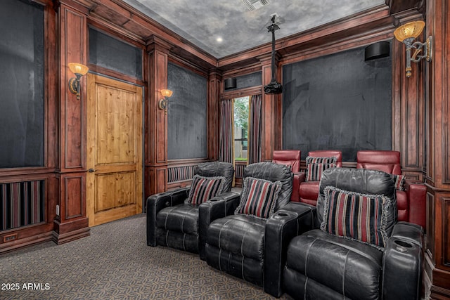 cinema room featuring ornamental molding and dark carpet