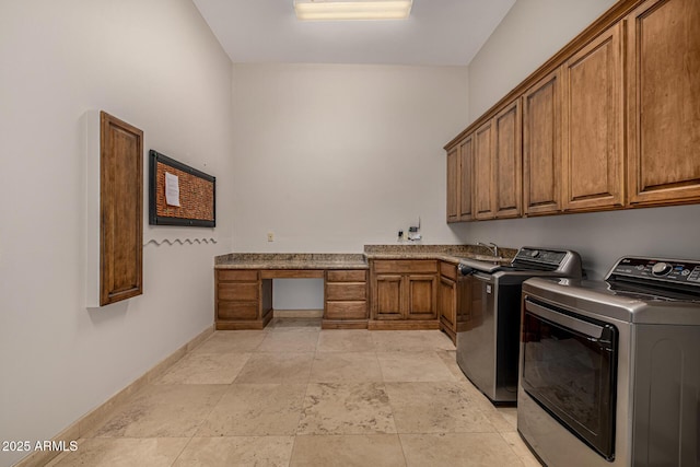 clothes washing area with washer and clothes dryer, sink, and cabinets