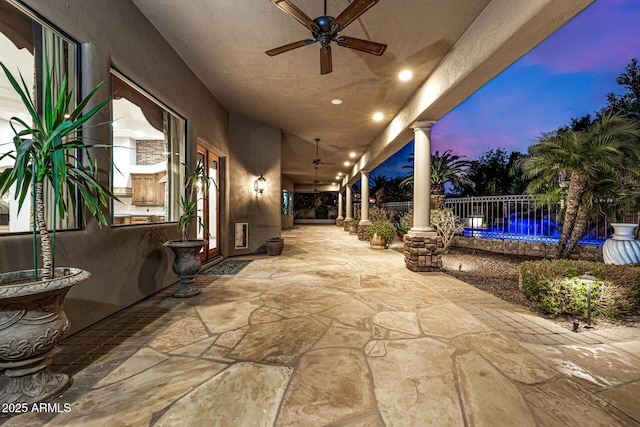 patio terrace at dusk featuring ceiling fan