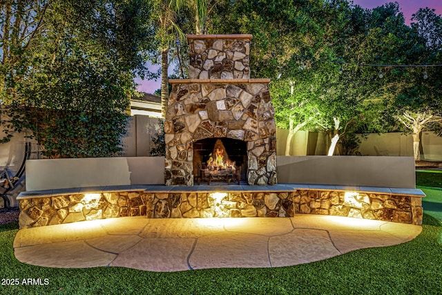 patio terrace at dusk with an outdoor stone fireplace