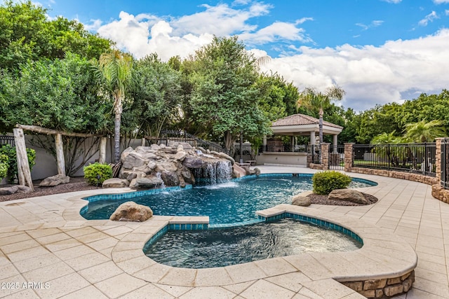 view of pool with pool water feature, a gazebo, an in ground hot tub, and a patio