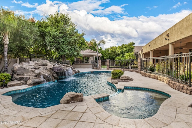 view of pool featuring ceiling fan, a gazebo, an in ground hot tub, and pool water feature