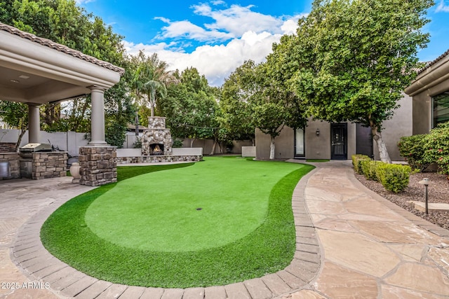 view of yard featuring exterior kitchen, a patio, and an outdoor stone fireplace