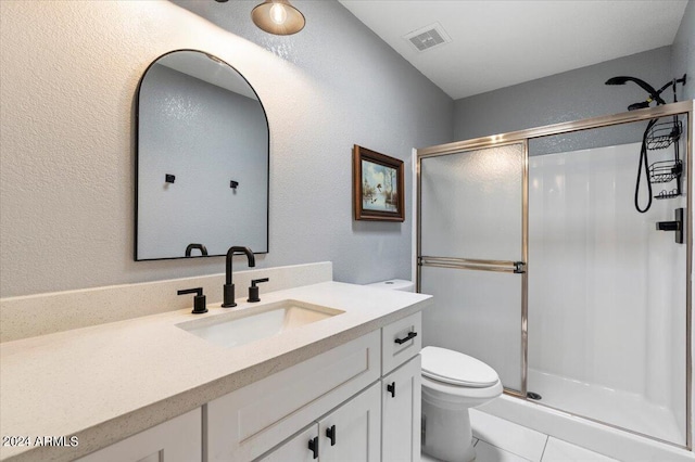 bathroom with visible vents, a textured wall, a stall shower, toilet, and vanity