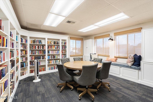 dining area with dark colored carpet, visible vents, a drop ceiling, and built in shelves