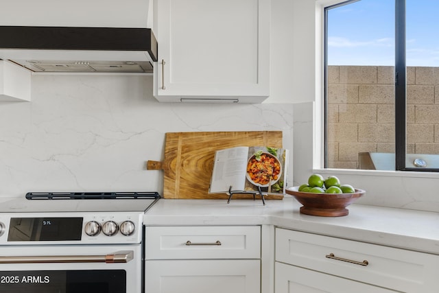 kitchen featuring electric stove, white cabinets, light countertops, decorative backsplash, and extractor fan