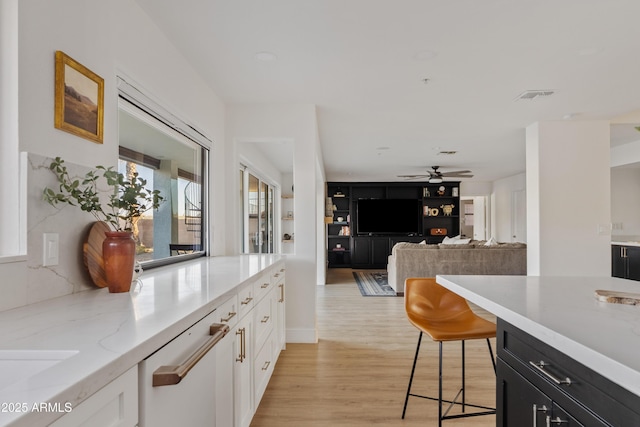 kitchen with visible vents, dishwasher, light wood-style floors, white cabinetry, and dark cabinets