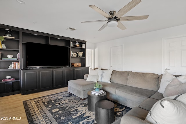 living room featuring visible vents, ceiling fan, and light wood finished floors