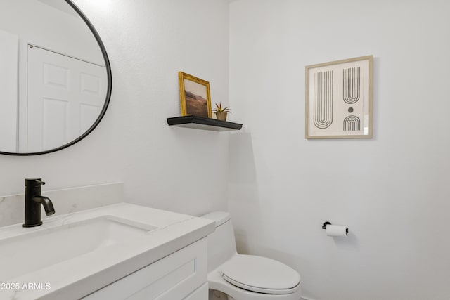 bathroom featuring toilet and vanity