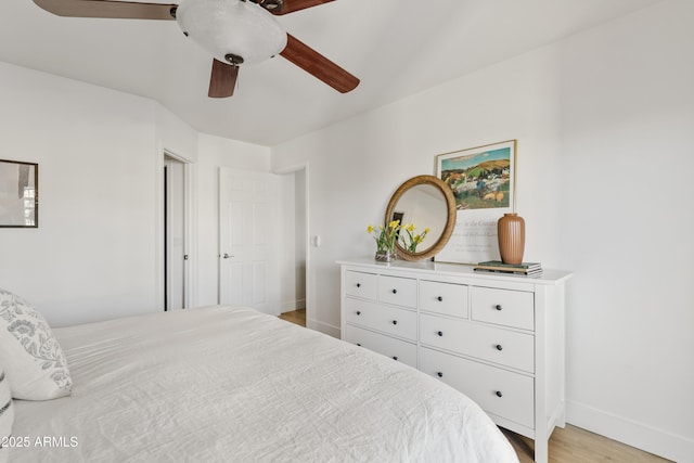 bedroom featuring ceiling fan, light wood-type flooring, and baseboards