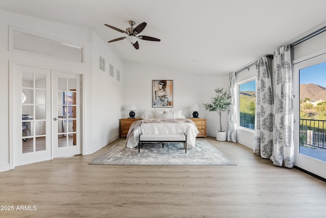 unfurnished bedroom with access to exterior, wood finished floors, french doors, and lofted ceiling