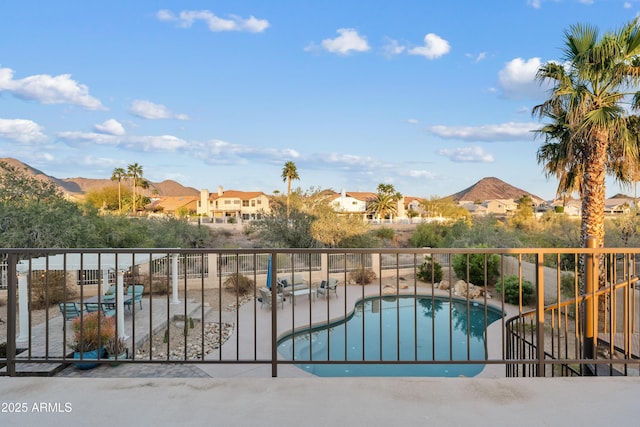 view of swimming pool with a patio area, a fenced in pool, a mountain view, and fence