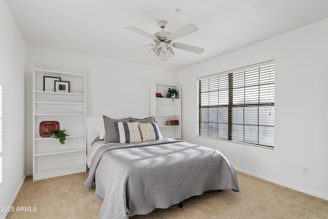 carpeted bedroom featuring baseboards and a ceiling fan