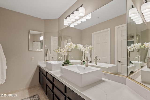 full bathroom featuring tile patterned floors, double vanity, visible vents, and a sink