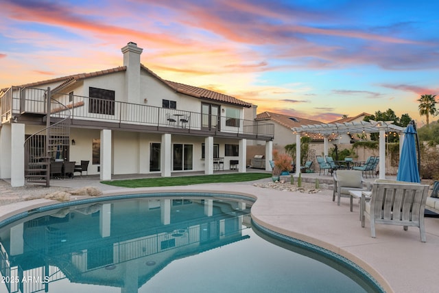 pool at dusk featuring stairs, outdoor dining area, an outdoor pool, a pergola, and a patio