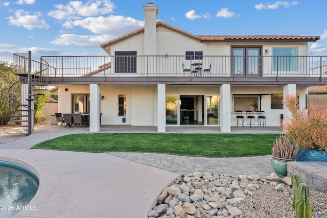 back of property featuring stairway, outdoor dining area, a patio area, and stucco siding