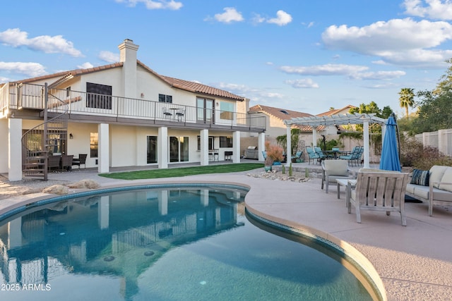 pool with a patio area, an outdoor hangout area, and a pergola