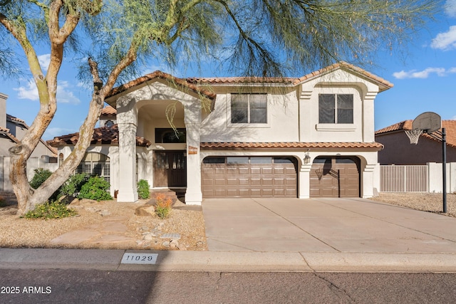 mediterranean / spanish-style house featuring fence, driveway, an attached garage, stucco siding, and a tiled roof