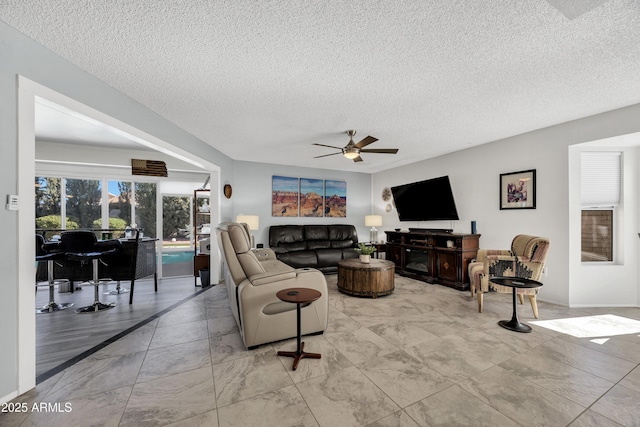 living room featuring a textured ceiling and ceiling fan