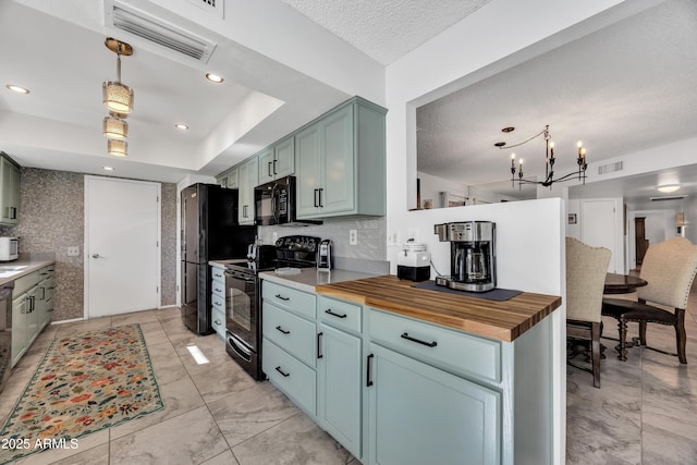 kitchen featuring wooden counters, a notable chandelier, pendant lighting, black appliances, and a raised ceiling