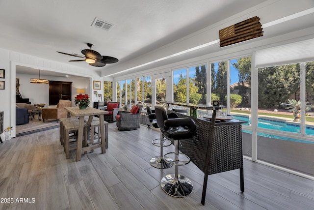 sunroom featuring ceiling fan and plenty of natural light