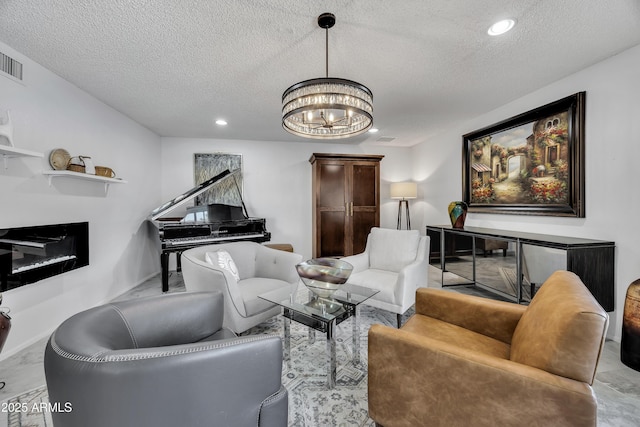 living room with a textured ceiling and a notable chandelier