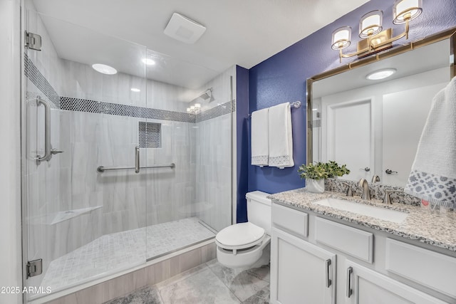 bathroom featuring toilet, vanity, and a shower with shower door