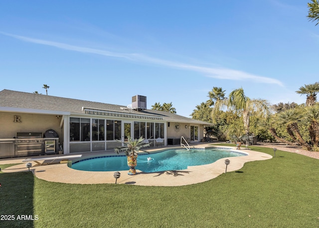 view of swimming pool featuring exterior kitchen, a grill, a yard, and a patio