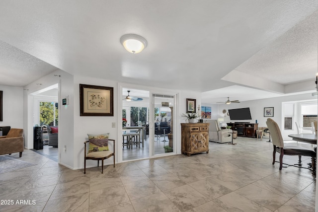 living room featuring a textured ceiling and ceiling fan