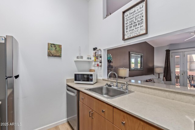 14203 N 19th Ave Unit 2036, Phoenix, AZ 85023 - kitchen with white microwave, a sink, stainless steel dishwasher, light countertops, and baseboards