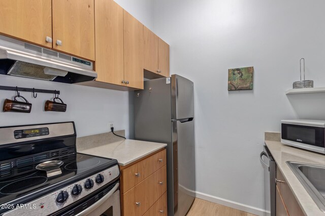14203 N 19th Ave Unit 2036, Phoenix, AZ 85023 - kitchen with stainless steel appliances, under cabinet range hood, light countertops, baseboards, and a sink