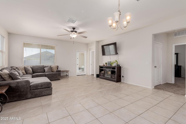 tiled living room with ceiling fan with notable chandelier