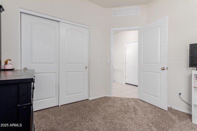 unfurnished bedroom featuring a closet and light colored carpet