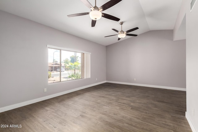 empty room with lofted ceiling, dark wood-style floors, visible vents, and baseboards