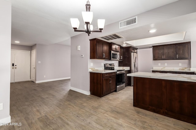 kitchen featuring hanging light fixtures, a notable chandelier, stainless steel appliances, dark brown cabinets, and light wood-type flooring