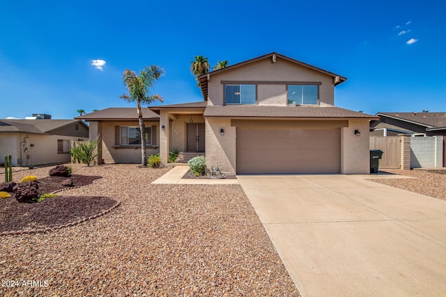 traditional home with driveway, an attached garage, fence, and stucco siding