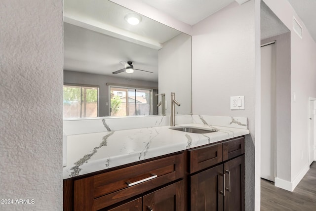 bathroom with visible vents, a ceiling fan, vanity, wood finished floors, and baseboards