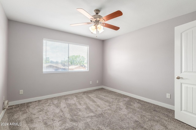 empty room with baseboards, a ceiling fan, and light colored carpet