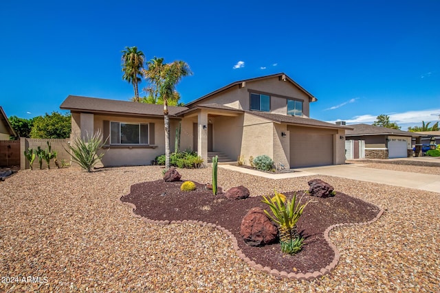 view of front facade featuring driveway, an attached garage, fence, and stucco siding