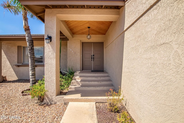 doorway to property featuring stucco siding