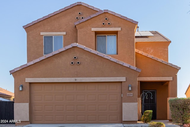 18359 W Eva St, Waddell, AZ 85355 - townhome / multi-family property with stucco siding, a tile roof, roof mounted solar panels, and an attached garage