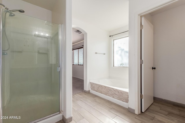 18359 W Eva St, Waddell, AZ 85355 - full bath with wood finished floors, a stall shower, a garden tub, and baseboards