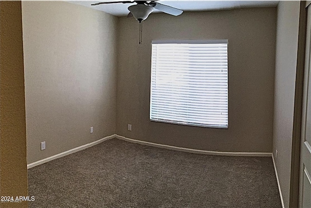 carpeted empty room with baseboards and a ceiling fan