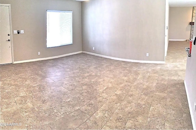 unfurnished room with baseboards