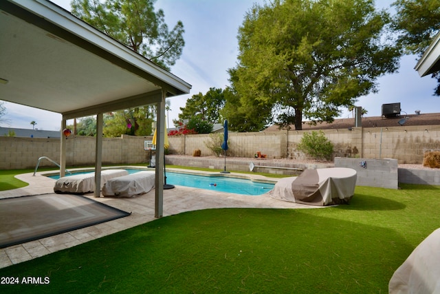 view of swimming pool featuring a fenced backyard, a lawn, a fenced in pool, and a patio