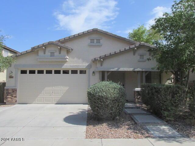 mediterranean / spanish-style house with stucco siding, driveway, a garage, and stone siding