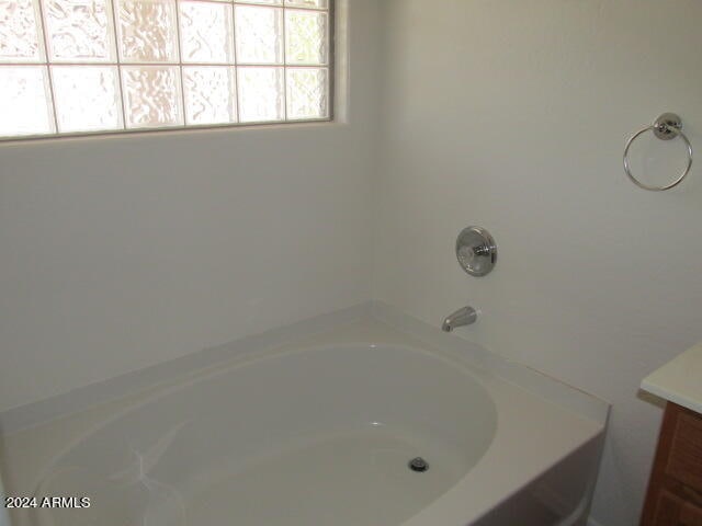 bathroom featuring a tub to relax in and vanity