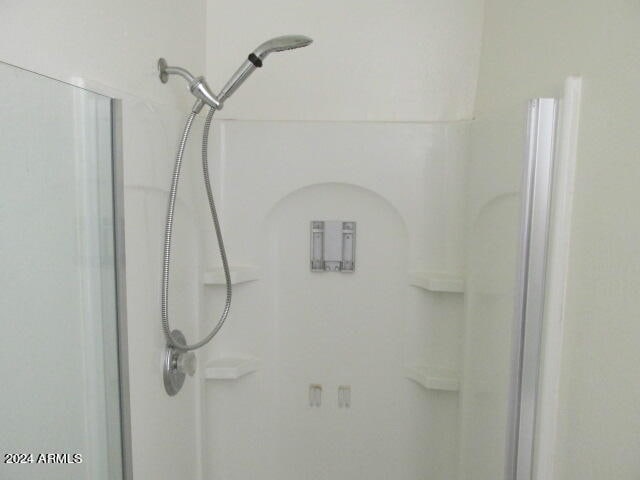 interior details featuring a shower with door