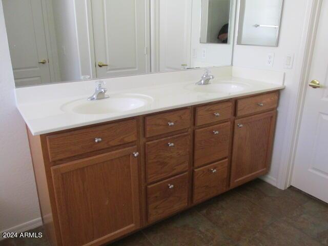 bathroom with double vanity, a sink, and tile patterned flooring