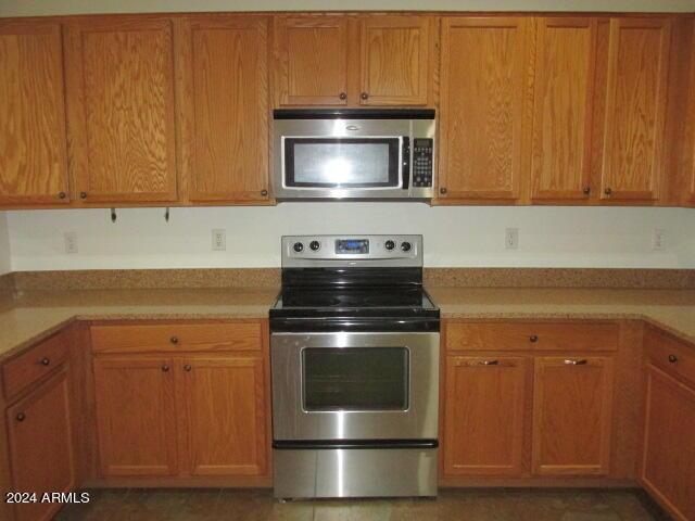 kitchen featuring light countertops, brown cabinets, and stainless steel appliances